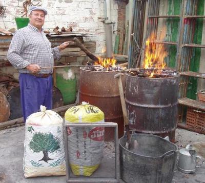 Juan Galán continúa con la tradición de hacer carbón con leña de olivo.