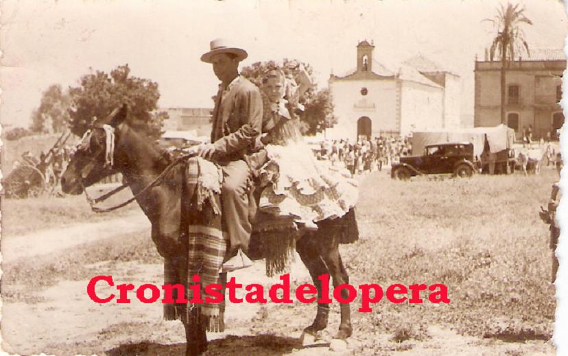 El loperano Manuel Acevedo Gutiérrez y su hija Rosi Acevedo Agudo en la Romería de Alharilla. Año 1951. Al fondo a la derecha la antigua Casa de la Cofradía de la Virgen de Alharilla de Lopera