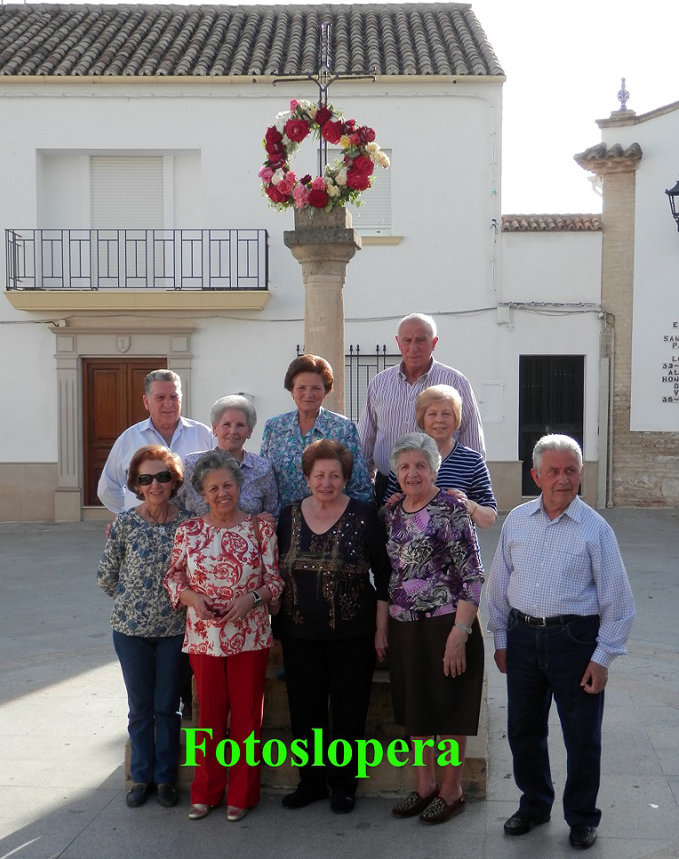 Las loperanas Feliciana Alcalá de la Torre y Conchi Lara Alcalá mantienen viva la tradición loperana de adornar con una corona de flores la Cruz de San Roque en la víspera del Día de la Santa Cruz