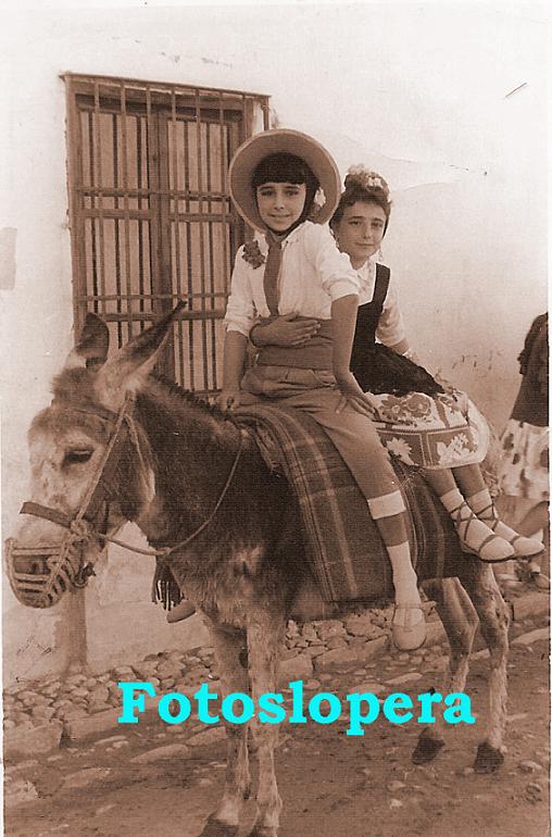 Las loperanas Juani Bueno y Manuela Coca a lomos de un burro en la Romería de San Isidro Labrador. Año 1959