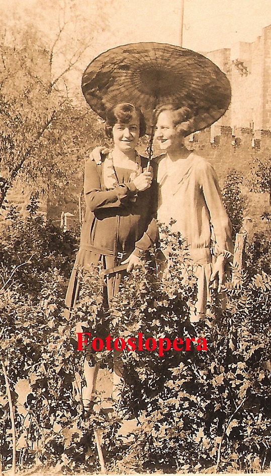 Las Hermanas Espín posan en el Jardín Municipal de Lopera con un quitasol y las vestimentas y peinados de la época, al fondo el Castillo. Años 30 del pasado siglo XX