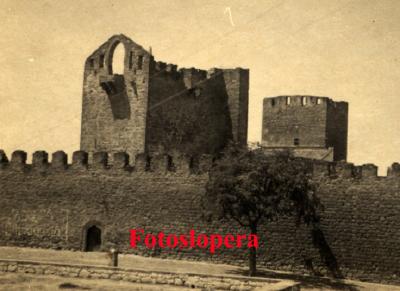 Vista parcial del Castillo de Lopera en el año 1949. Detalle de la puerta principal (a la izquierda con un anuncio publicitario de TERESA Churrería) y el cuerpo de campanas de la Torre de Santa María