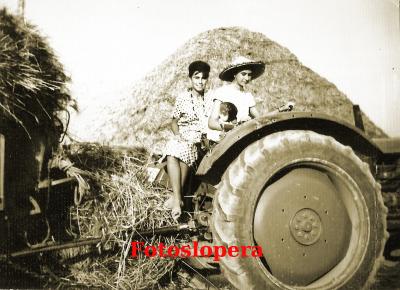 Conchi Bellido y Helga Walter en un tractor, junto a un almiar en el Cortijo de los Morrones. Año 1959
